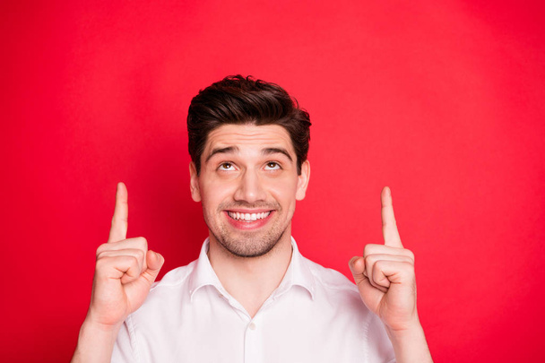 Close-up portrait of nice attractive cheerful cheery glad positive funny content guy pointing two forefingers up holiday gift surprise present ad advert isolated over bright vivid shine red background - Fotó, kép