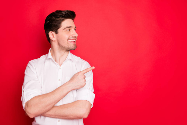 Portrait of his he nice attractive cheerful cheery content guy employee pointing forefinger aside ad advert tips feedback sale discount solution isolated over bright vivid shine red background - Valokuva, kuva