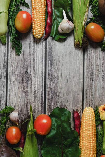 Healthy food clean eating selection. Corn, tomatoes, zucchini, carrot, beetroot, garlic, bean on wooden background. Food concept. Flat lay, top view. Free space for your text. - Foto, imagen