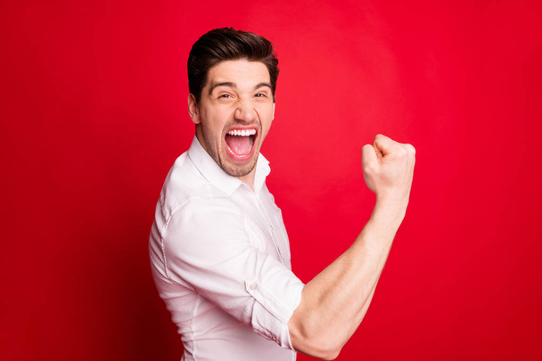 Foto de desfrutar de regozijo homem vestindo roupas formais mostrando sua felicidade e satisfação enquanto isolado com fundo vermelho
 - Foto, Imagem