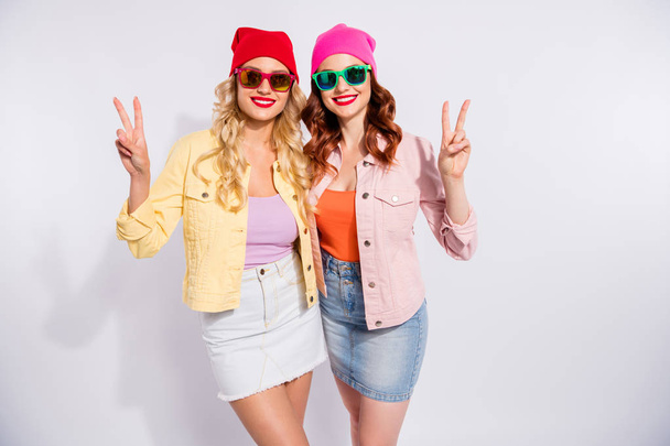 Photo of two pretty ladies showing v-sign symbols wear sun specs casual clothes isolated white background - Φωτογραφία, εικόνα