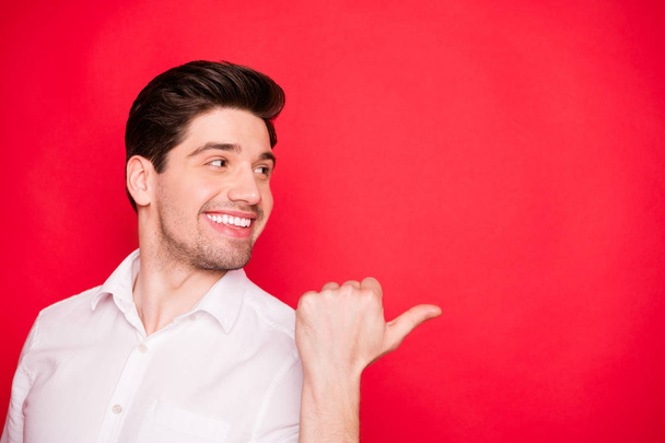 Close-up portrait of his he nice attractive cheerful cheery content guy pointing thumb aside advert ad novelty sale discount solution decision isolated over bright vivid shine red background - Fotografie, Obrázek