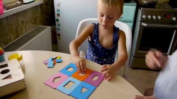 αυτιστικό παιδί συλλέγει χρωματιστά παζλ στην τάξη - Πλάνα, βίντεο