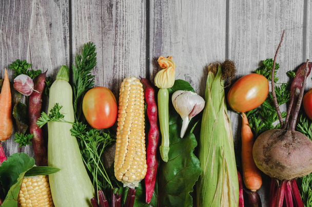 Assorted fresh vegetables on wooden background. Corn, tomatoes,  - Photo, image