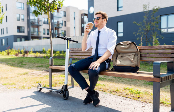 businessman with scooter drinking coffee in city - Фото, изображение