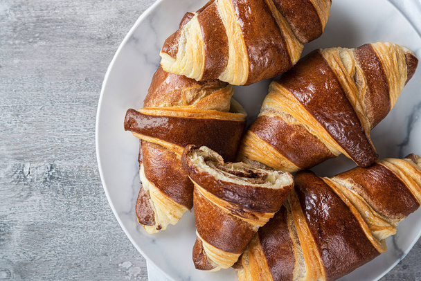 purra croissantteja suklaalla valkoisella lautasella, ranskalainen keittiö, aamiainen
 - Valokuva, kuva