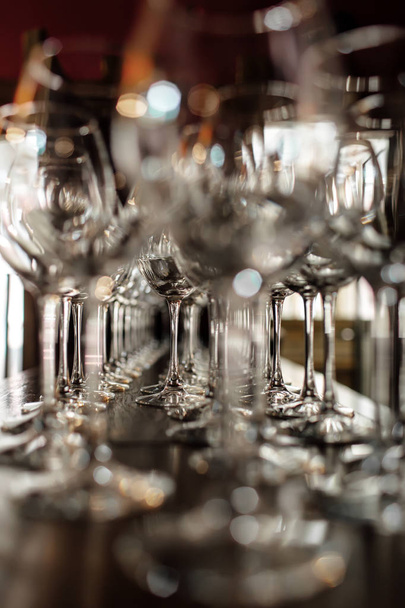 verres à vin vides. De beaux verres neufs pour le vin du verre se trouvent en rangées égales sur une table en bois dans un restaurant. focus sélectif
 - Photo, image