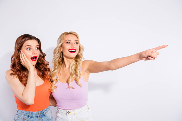 Photo of two pretty ladies noticed shop with low prices wear casual tank-tops isolated white background - Φωτογραφία, εικόνα