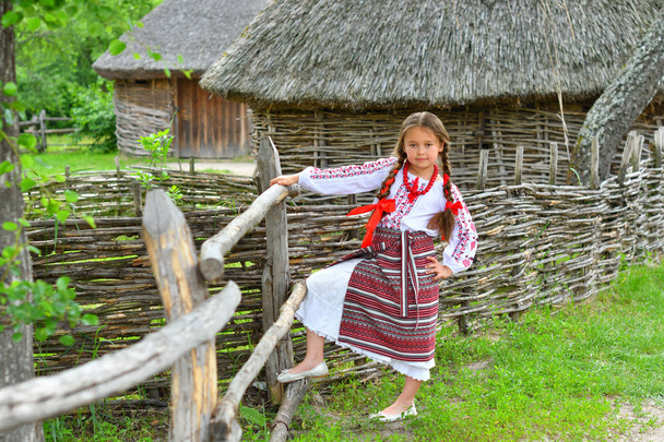 portret ukraińskiej pięknej dziewczyny w vyshivanka obok starego drewnianego domu. dziewczynka w haftem. Koncepcja tradycji narodowych - Zdjęcie, obraz
