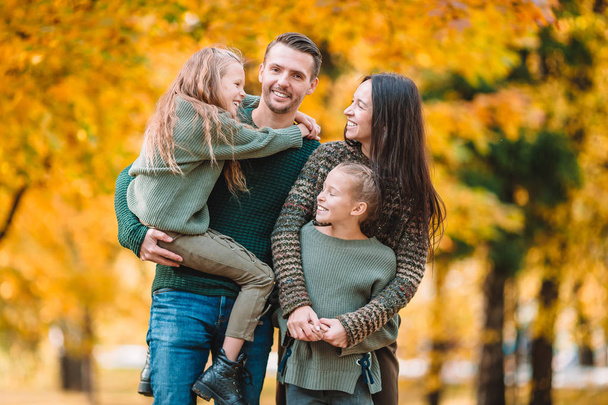 Portret van een gelukkig gezin van vier in de herfst - Foto, afbeelding