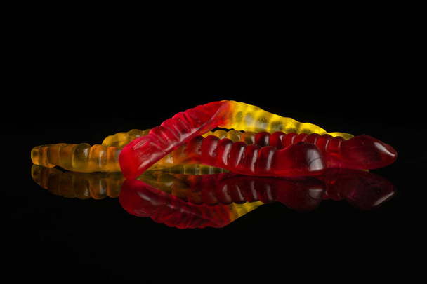 Jelly worm candy isolated on black glass - Foto, Imagen