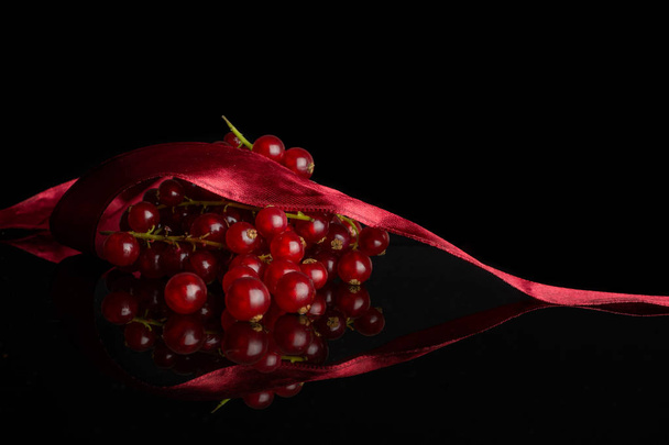 Fresh red currant isolated on black glass - Zdjęcie, obraz