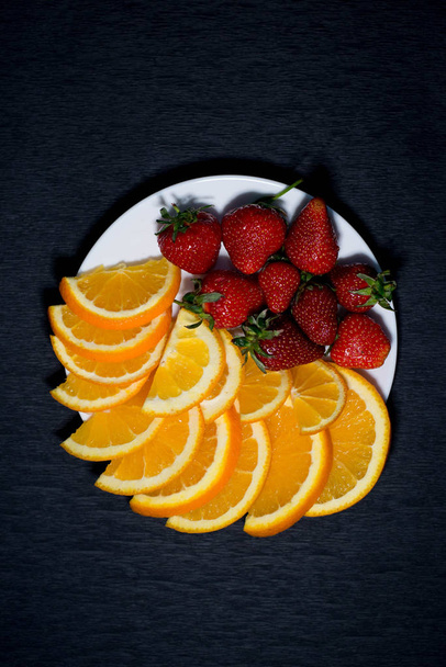 Erdbeeren und Orange auf weißem Teller - Foto, Bild
