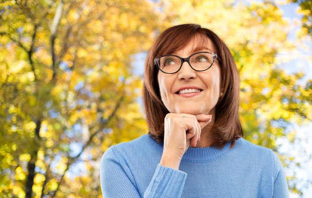 portrait of senior woman in glasses dreaming - Foto, Imagen
