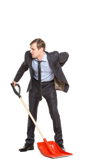 allegory. office worker, manager, tortured businessman in suit and tie with a shovel on a white background - Foto, afbeelding