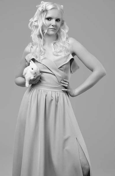 Albino blond girl in elegant dress posing with cute little rabbi - Zdjęcie, obraz