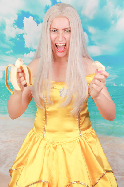 жовтий свіжий банановий фрукт розбився тримається в руках жінки
 - Фото, зображення