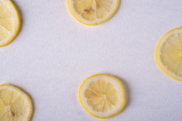 Свежие ломтики лимона на белом фоне, текстура, вид сверху, плоский уголок
 - Фото, изображение