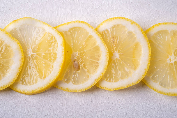 Свежий лимон ломтики на белом сером фоне, текстура, вид сверху, закрыть, макрос
 - Фото, изображение