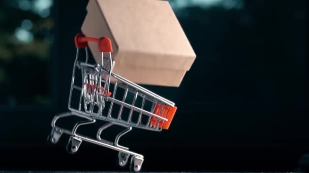 Slow motion shot of shopping cart with box falling down. Retail problems or accident related conceptual clip - Filmati, video