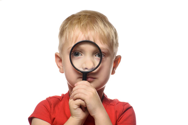 Blond boy with a magnifying glass in his hands. Little explorer. White background - Foto, afbeelding