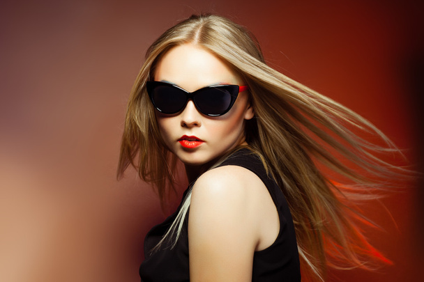 Mujer de moda en gafas de sol, tiro al estudio. Maquillaje profesional y peinado
 - Foto, Imagen