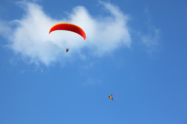 The red parachute flies in the blue sky - Valokuva, kuva