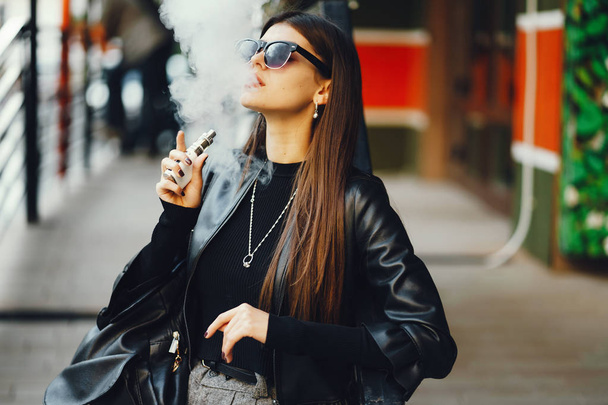 stylish girl smoking an e-cigarette - Photo, image