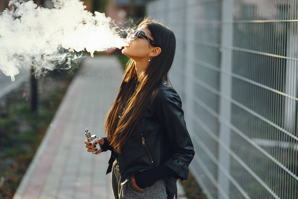 stylish girl smoking an e-cigarette - Fotoğraf, Görsel