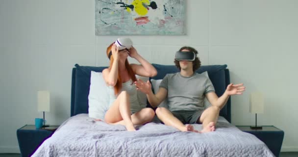 Jong paar is vermakelijk in bed, kijken naar 360 video in vr Headsets - Video