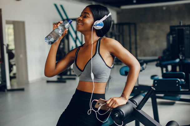 A beautiful black girl is engaged in a gym - Foto, afbeelding