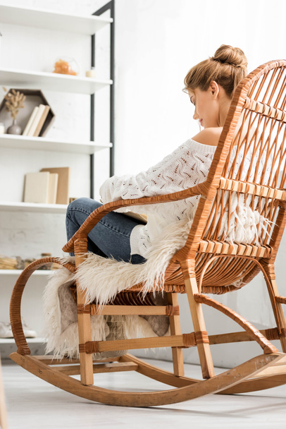 visão traseira da mulher em suéter branco sentado na cadeira de balanço
 - Foto, Imagem