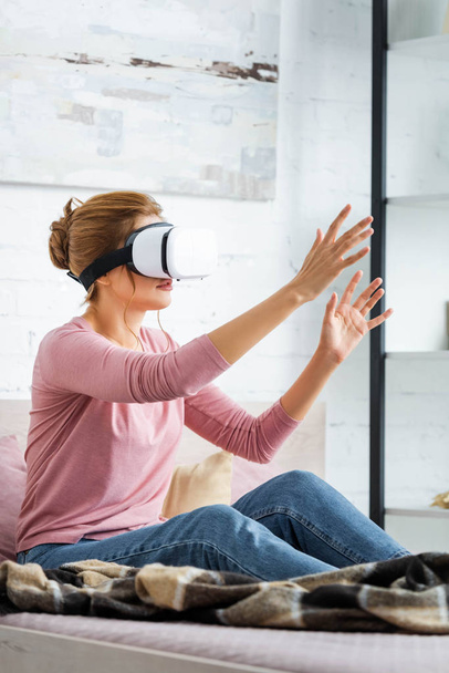 young adult woman playing with virtual reality headset in apartment  - Foto, immagini