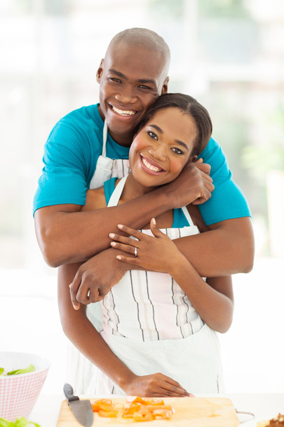 african couple hugging in home kitchen - Foto, afbeelding