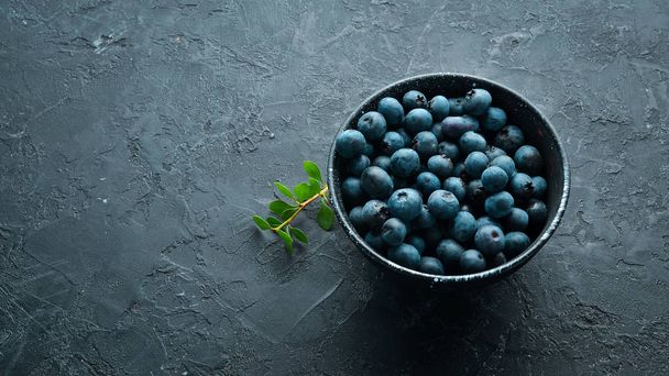 Fresh blueberries on a black stone background. Free copy space. - Zdjęcie, obraz