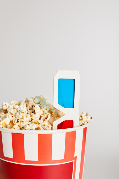 tasty fresh popcorn in bucket with 3d glasses isolated on grey - Foto, Imagen