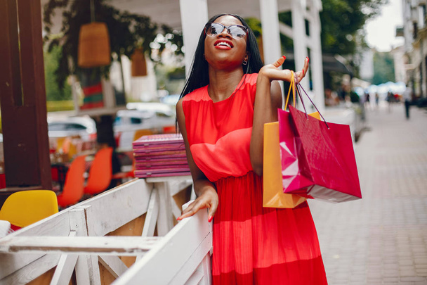 Beautiful black girl with shopping bags in a city - Fotoğraf, Görsel