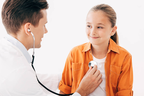 pediatrist w białej sierści rozpatrując dziecko stetoskop na białym tle - Zdjęcie, obraz