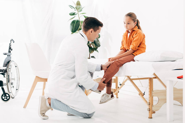 Kinderarzt im weißen Kittel untersucht Kind in Klinik - Foto, Bild