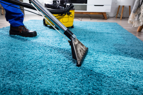 Close-up Of A Person Cleaning Carpet With Vacuum Cleaner - Foto, imagen
