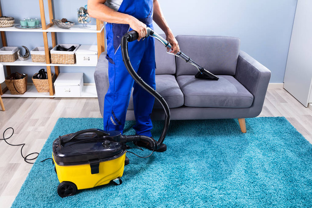 Photo Of Person Cleaning Sofa With Vacuum Cleaner - Фото, изображение