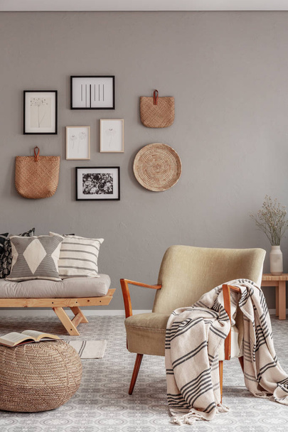 Trendy creme colored armchair in Scandinavian living room interior with gallery of posters on beige wall - Zdjęcie, obraz