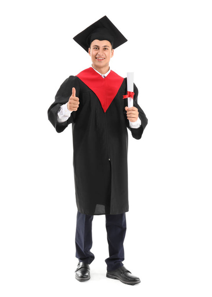 Jovem estudante do sexo masculino em roupão de solteiro mostrando thumb-up no fundo branco
 - Foto, Imagem