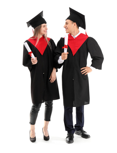 Fiatal hallgatók Bachelor köpenyben és diplomák fehér alapon - Fotó, kép