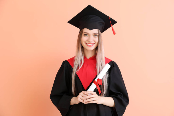 junge Studentin im Bachelor-Gewand und mit Diplom auf farbigem Hintergrund - Foto, Bild