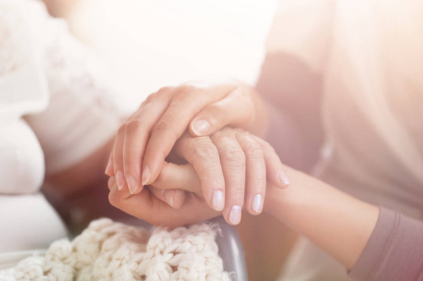 Closeup of hands of a young girl holding hand of an senior woman - Photo, Image