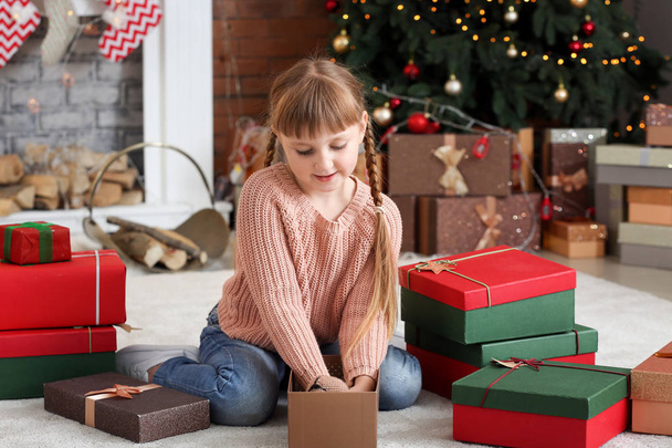 Cute little girl with Christmas gifts at home - Foto, imagen