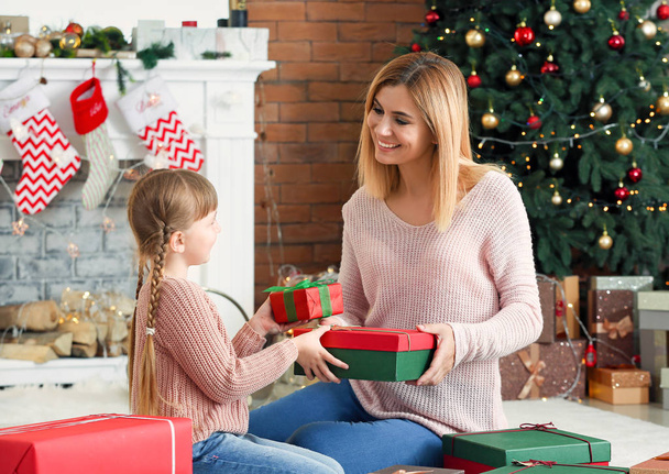 Cute little girl and her mother with Christmas gifts at home - Foto, afbeelding
