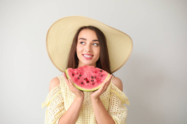 Gyönyörű fiatal nő, szelet friss görögdinnye a világos háttér - Fotó, kép