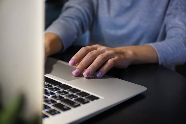 Женщина работает на ноутбуке за столом вечером, крупным планом
 - Фото, изображение